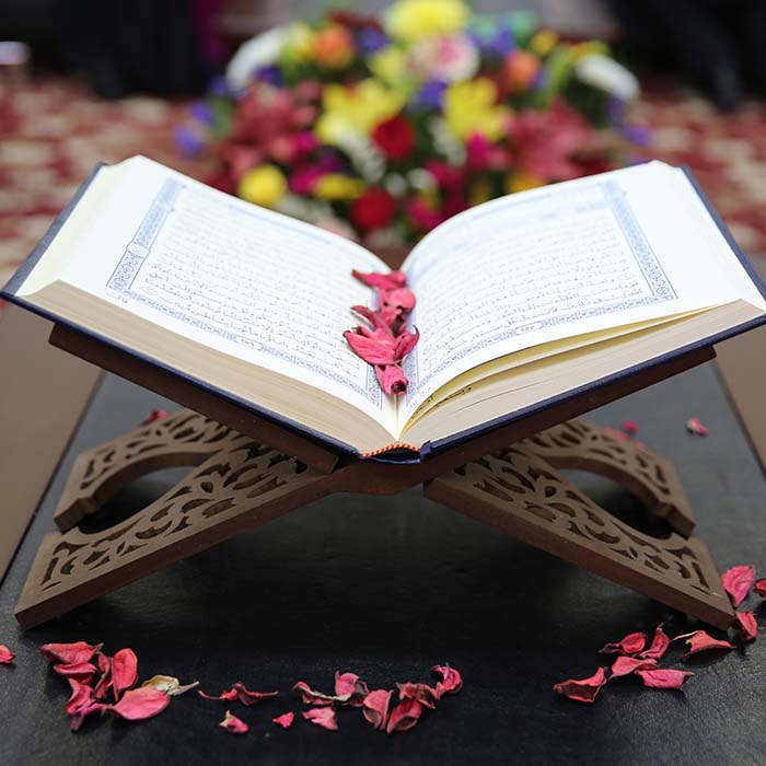 Quran on a stand with rose petals