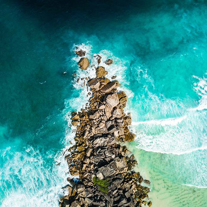 Aerial view of a rock jutting out into the ocean