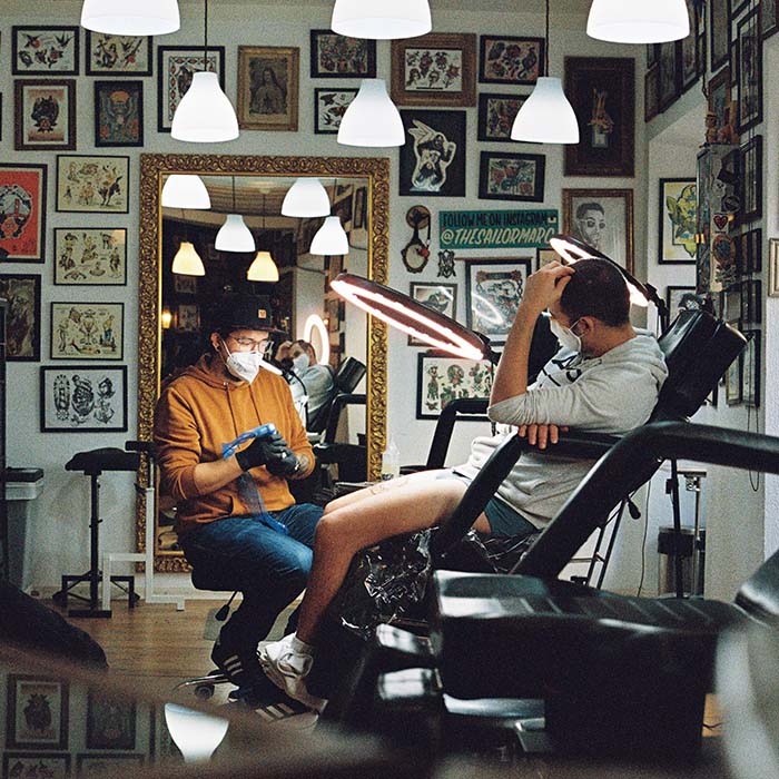 man sitting in a chair getting a tattoo done