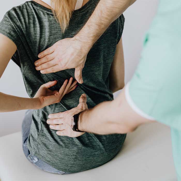 a physician inspecting a back injury