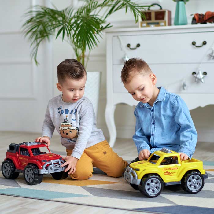 two children playing with toy cars